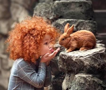 A cute ginger girl blows kisses to her tiny friend