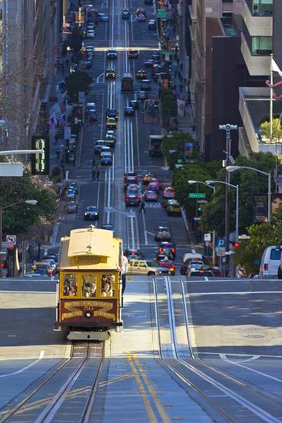 A cable car on the steep slopes of California street stops to let off passengers. Its a trek up to the top of Nob hill.