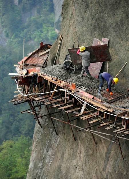 Chinese workers risk lives to build road on a cliff with no safety equipment. The 21 builders are working in dangerous conditions to build China's  longest sightseeing mountain road in pingjiang Hunan province.
