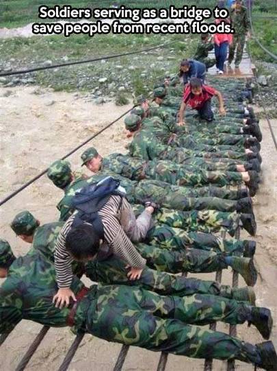 Soldiers serving as bridge for kids during flood