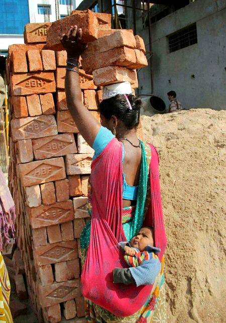 Incredible image of mother carrying bricks on head and baby on back...An image showing a hard-working mother in india carrying six bricks on her head while balancing her baby in a sling on her back has astonished Reddit users💕💕
